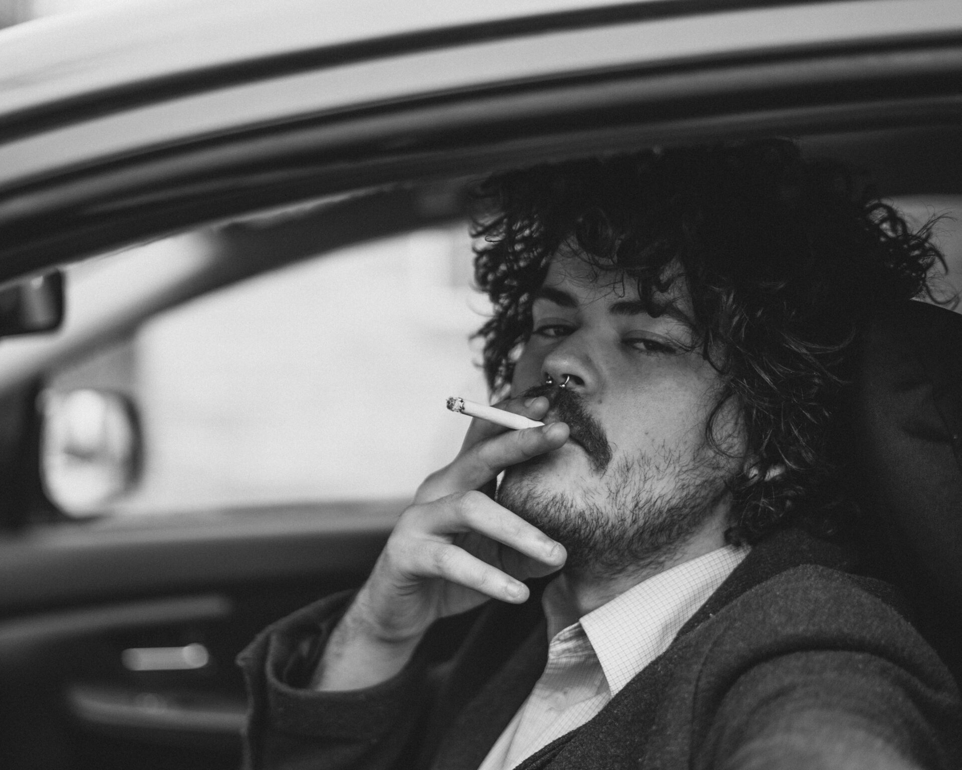A Man Smoking a Cigarette in a Car